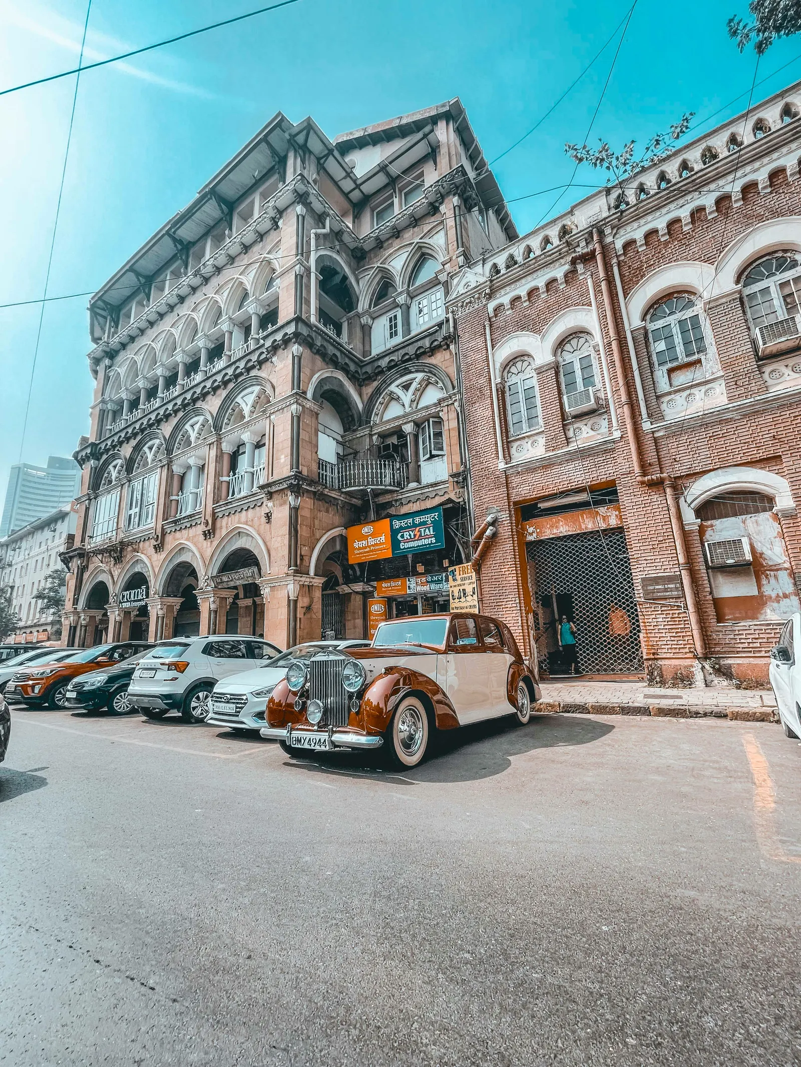 An ornate South Mumbai street façade with taxis below